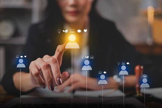 Businesswoman interacting with digital workforce icons on a touchscreen.